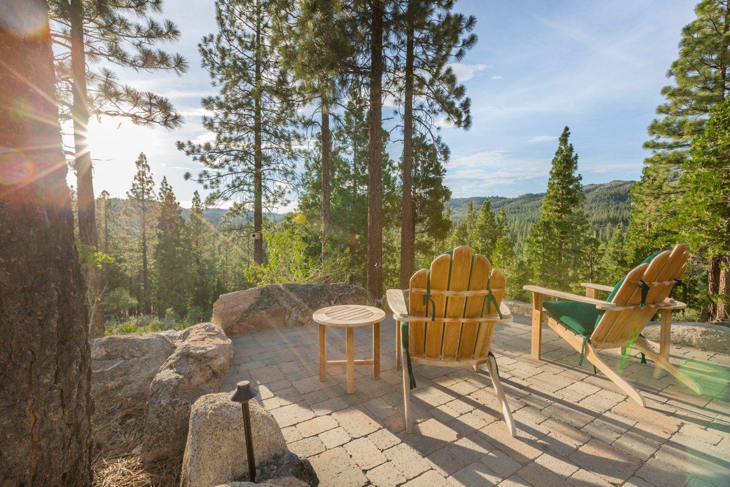 A stone patio at golden hour, looking out over the pines of the Lost Sierra